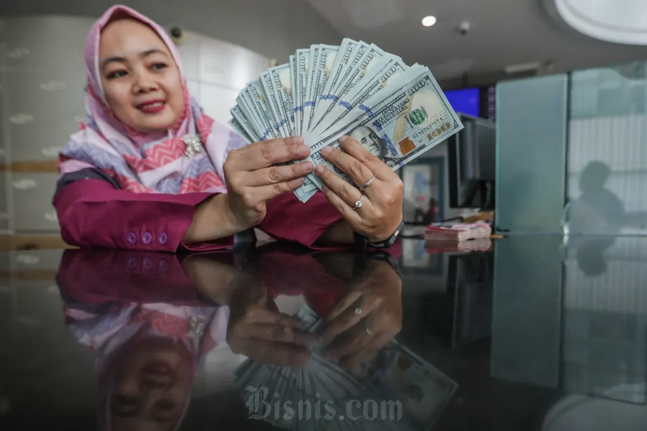 Karyawan menunjukkan uang dolar AS di salah satu tempat penukaran uang, Jakarta, Selasa (27/10/2026). Nilai tukar rupiahÂ melemah ke ke Rp18.155 per dolar AS pada perdagangan (27/10), dipengaruhi ketidakpastian global dan menanti hasil rapat FOMC juga Geopolitik Timur Tengah turut membebani